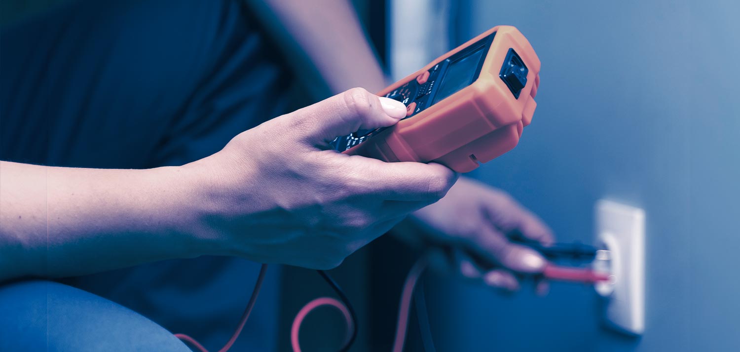 Hände Messen mit einem Messgeräte eine Steckdose in der Wand