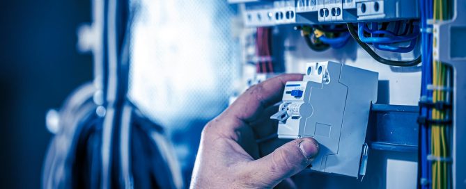 Hände montieren an einem Schaltschrank