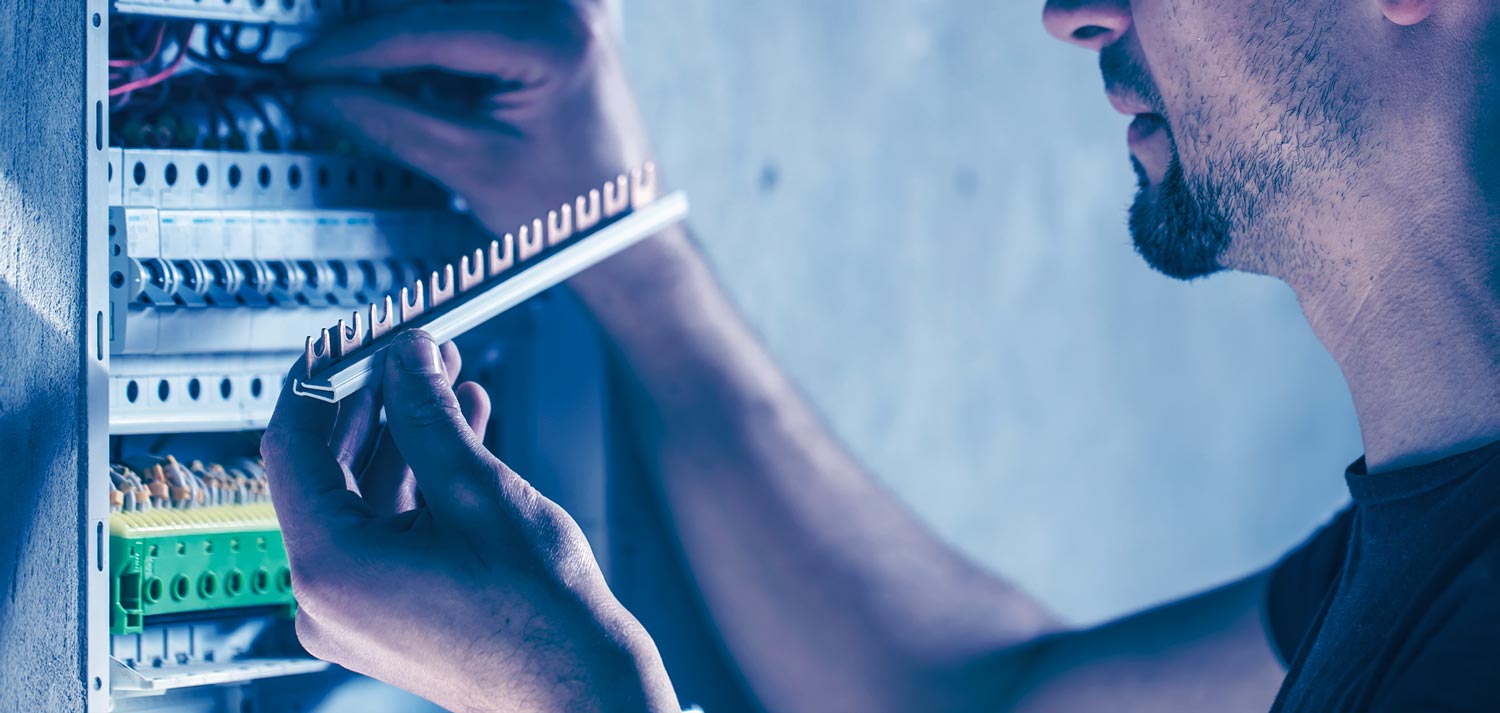 Mann setzt neue Elemente in einem Schaltschrank